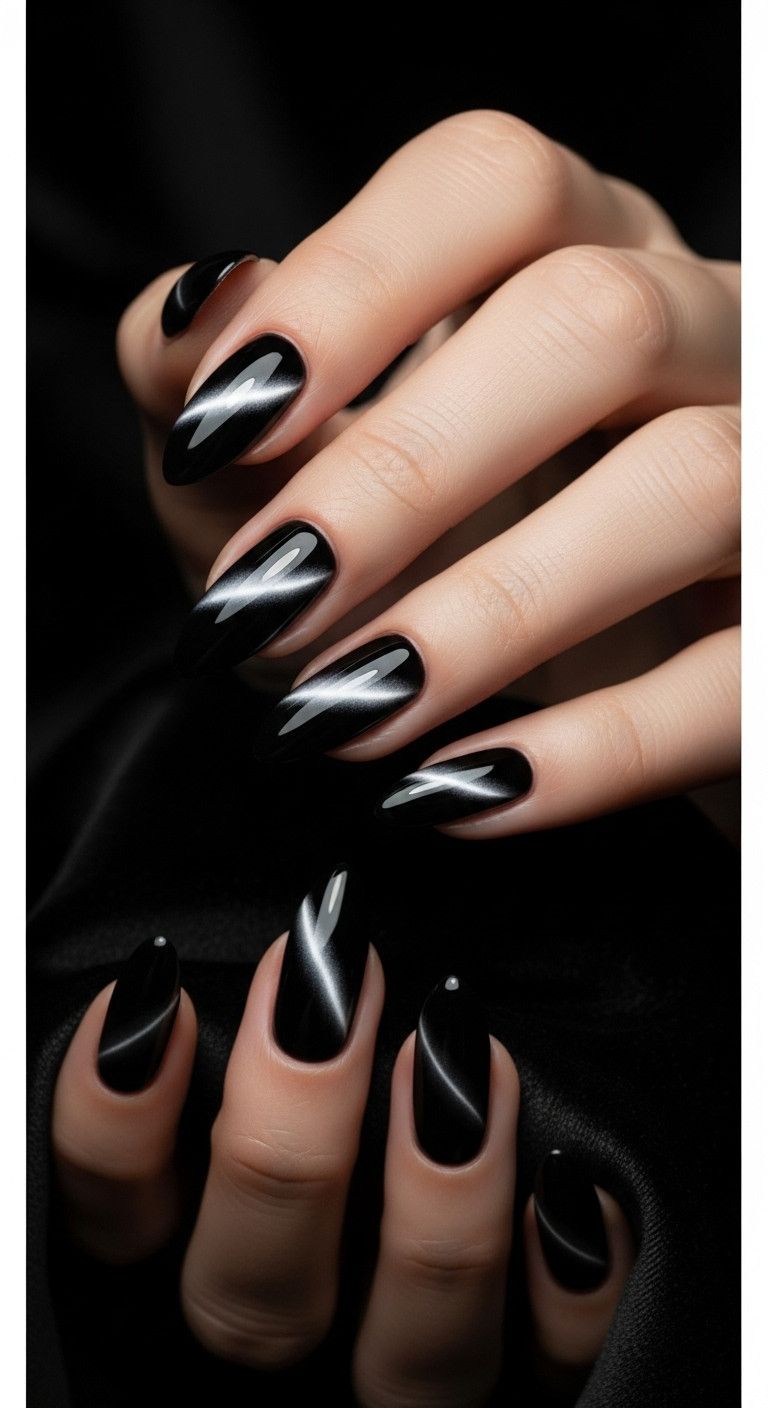 Elegant almond nails with chic black cat-eye magnetic polish on a dark velvet background perfect for a sophisticated look