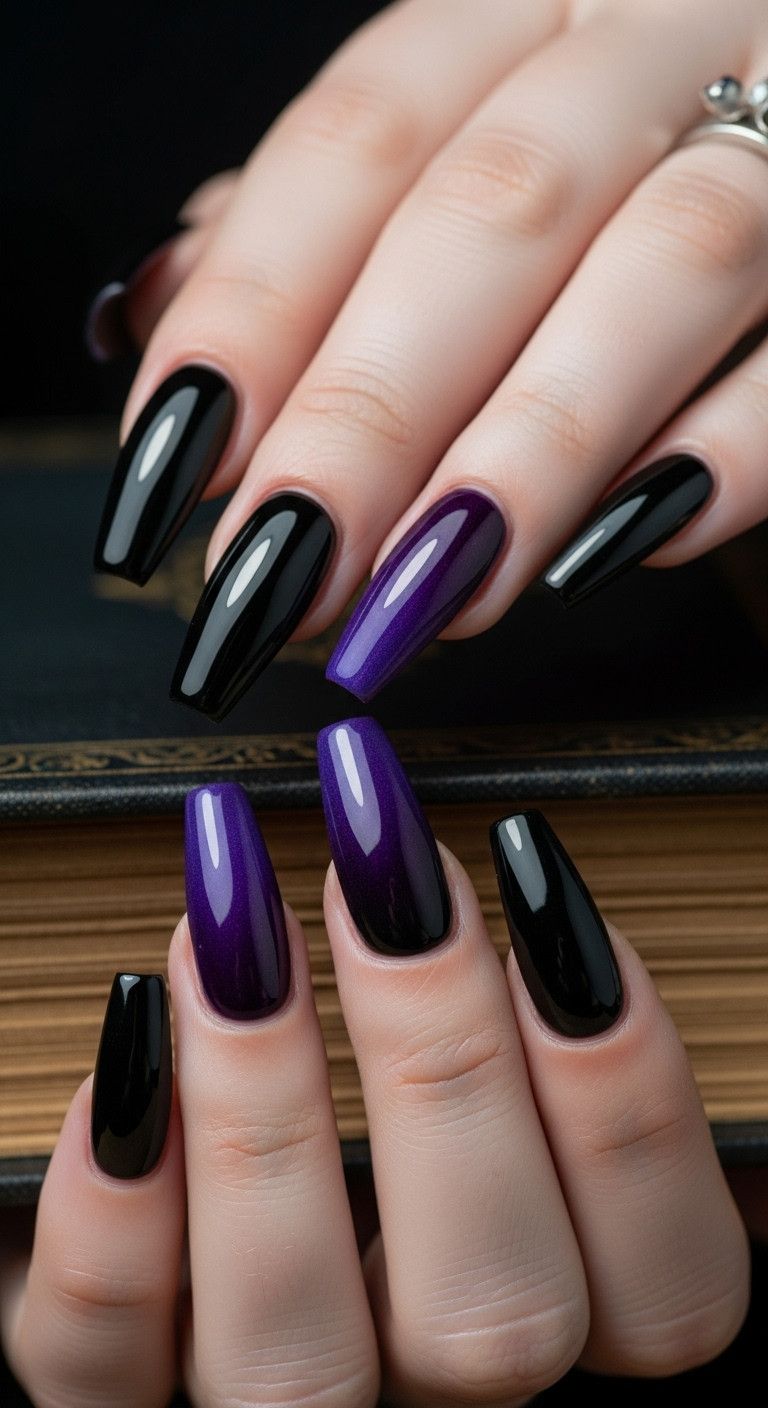 Long coffin nails with royal purple and black ombré resting on an old leather-bound book for a vampy look