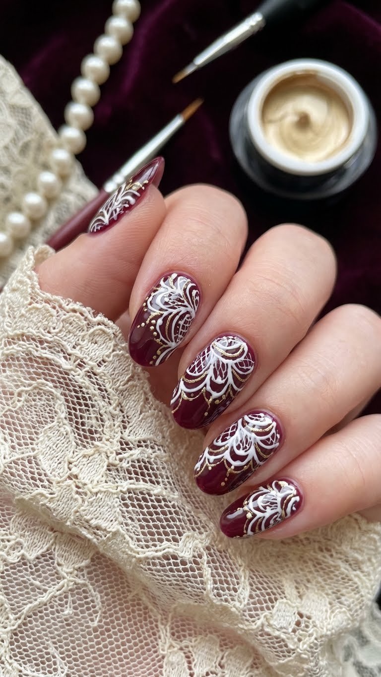 Intricate blooming gel lace nail art: white vintage pattern, metallic gold on deep burgundy base. Elegant gel manicure, antique cloth.