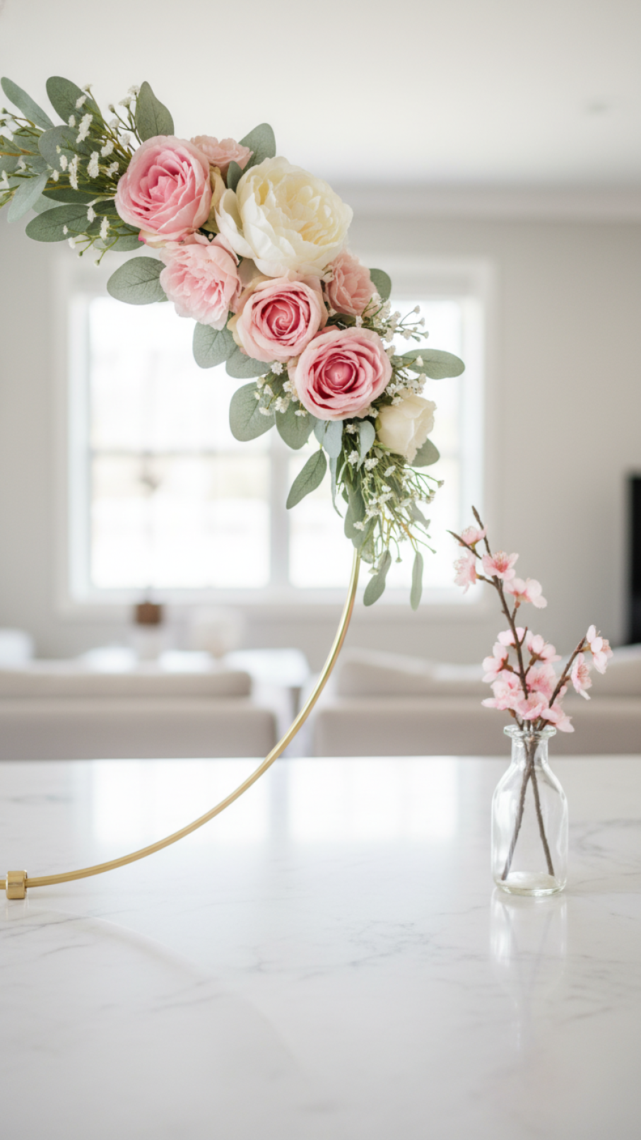 Elegant gold metal hoop Valentine wreath with pink roses and eucalyptus leaves on marble countertop.