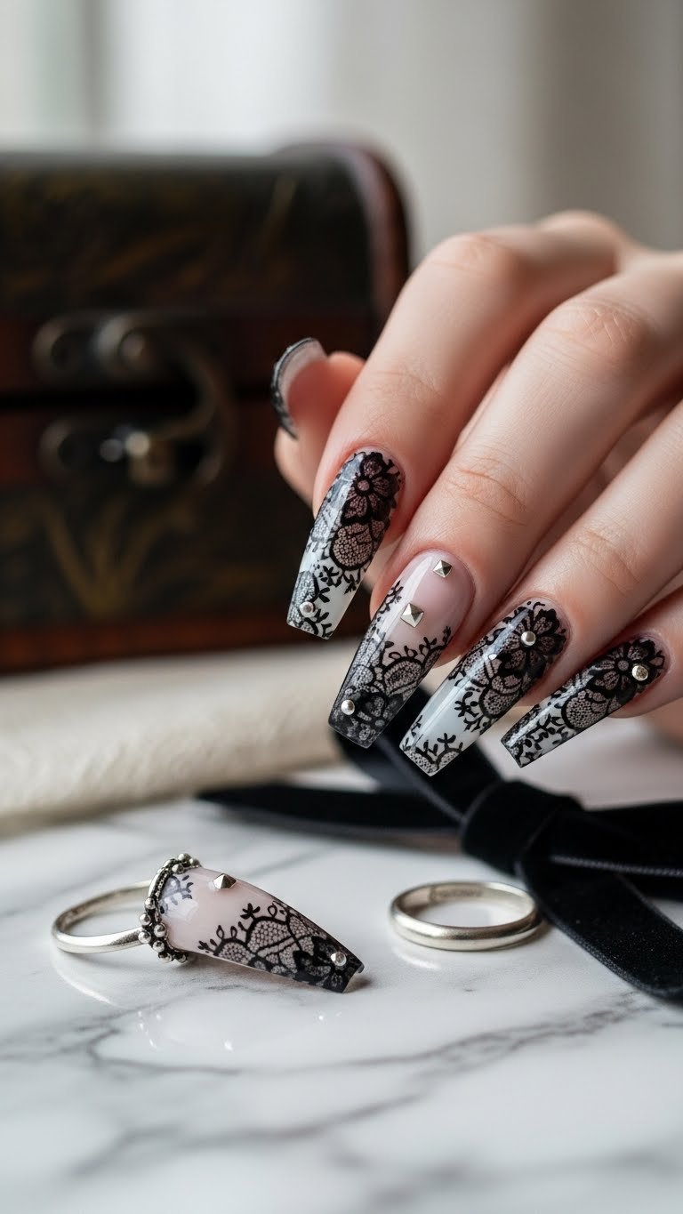 Long coffin nails with delicate black lace patterns on sheer white base with silver studs