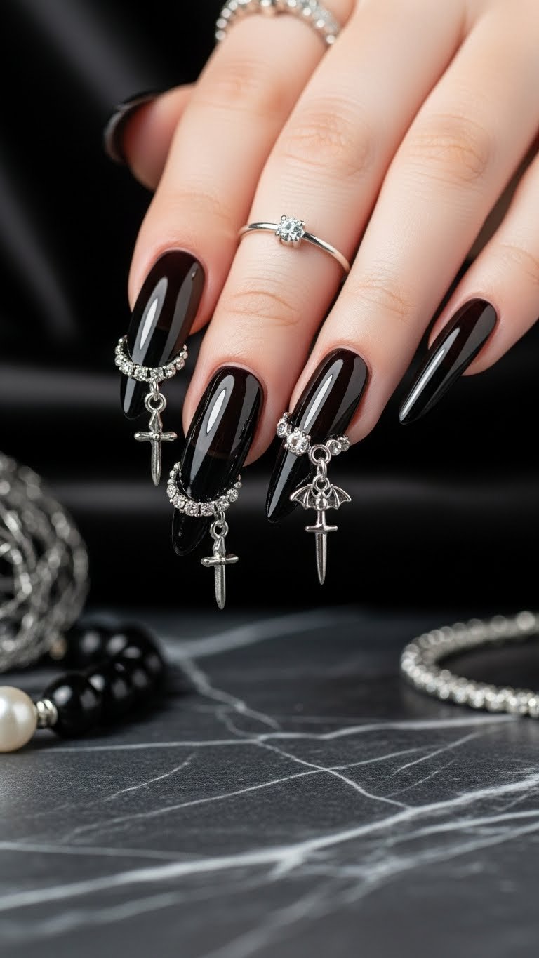Long pointed almond acrylic nails with sheer black jelly polish featuring silver rings piercing edges with gothic charms dangling.